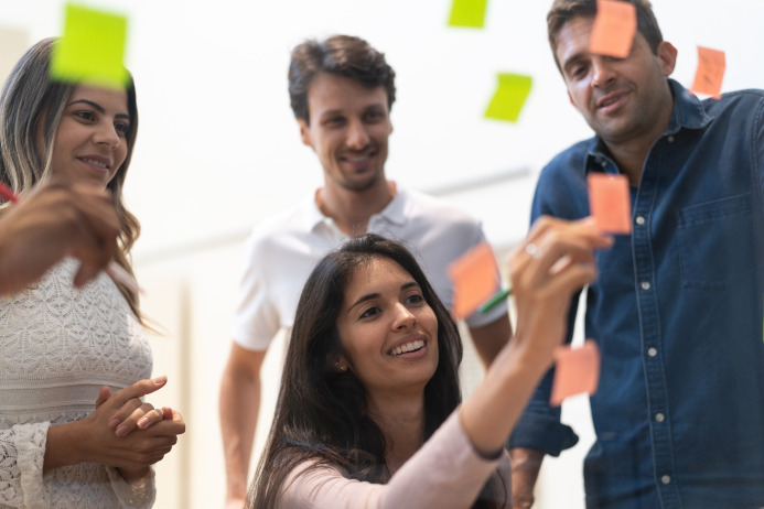 Vier mensen in een overleg met post-it papiertjes