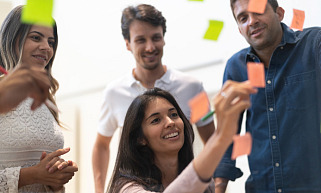 Vier mensen in een overleg met post-it papiertjes